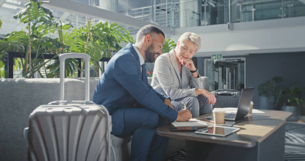 istock Diversity, teamwork or business people consulting, writing on notebook or strategy on sofa in airport. Travel meeting or corporate woman and man working on marketing, advertising or company proposal 1437931534