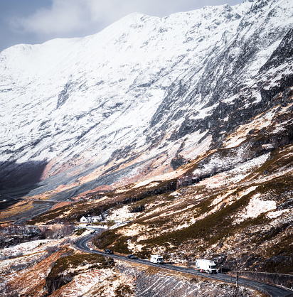 Cold winter conditions with daytime traffic on a winding hill section of the A82 through Glencoe in Scotland.