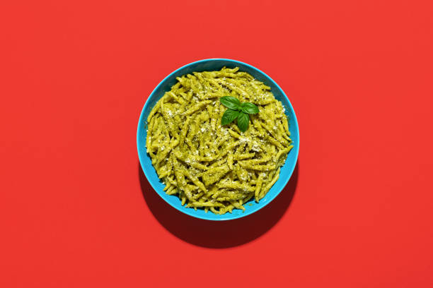 istock Pasta with pesto sauce, top view on a red background 1437941370