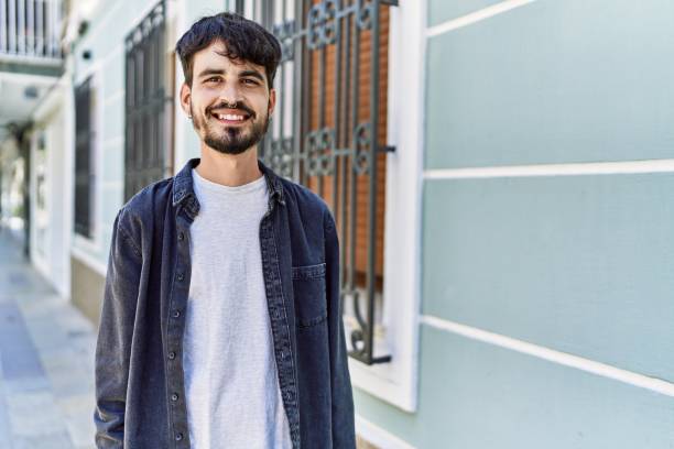 istock Young hispanic man smiling happy standing at the city. 1437941936