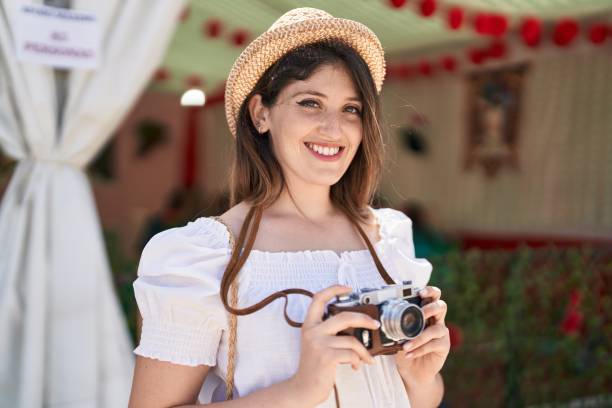 istock Young hispanic woman tourist smiling confident using camera at restaurant 1437942231