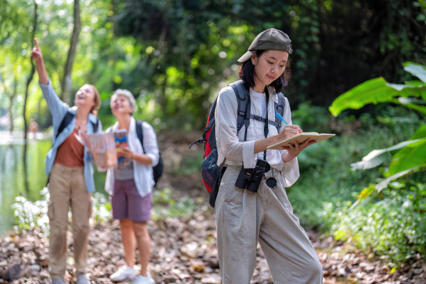istock Backpack tourist travel outdoor adventure bird study using binoculars looking and record to book 1437942913
