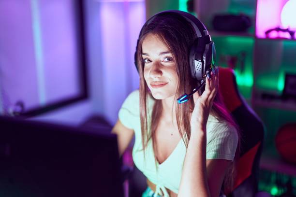 istock Young beautiful hispanic woman streamer playing video game using computer at gaming room 1437942975