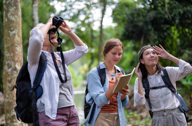 istock Backpack tourist travel outdoor adventure bird study using binoculars looking and record to book 1437942984
