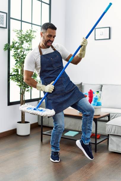 istock Young hispanic man cleaning floor and singing song using mop as a guitar at home 1437943849