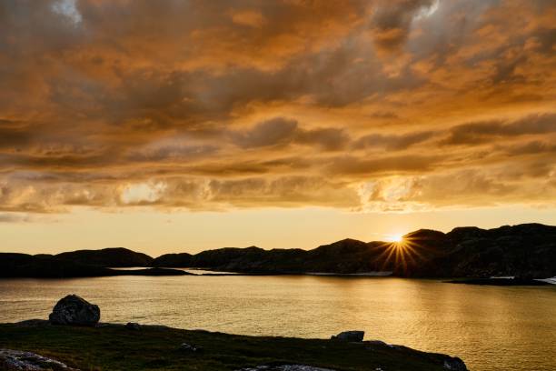 Boulder and hills above Oldshoremore Beach Bay at sunset