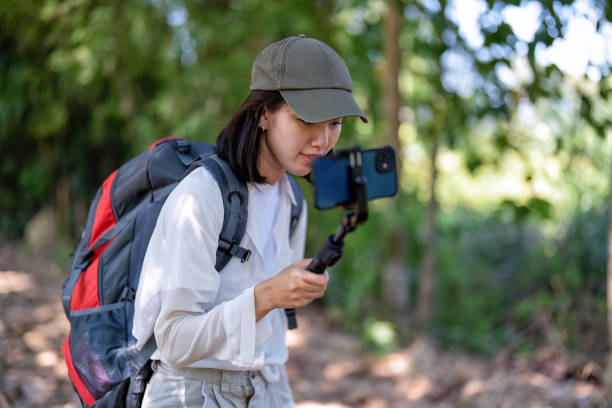 istock Young backpack hiking botany study woman walking in the forest and pay attention looking tree leave 1437945378
