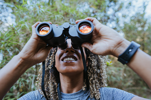 Backpacker woman using binoculars