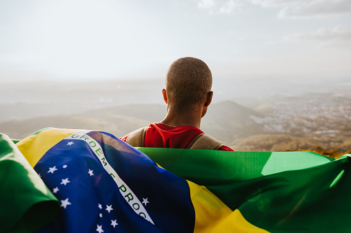Man holding the flag of Brazil