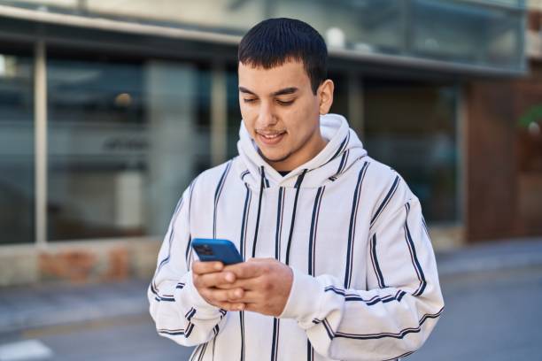 istock Young man smiling confident using smartphone at street 1437947549