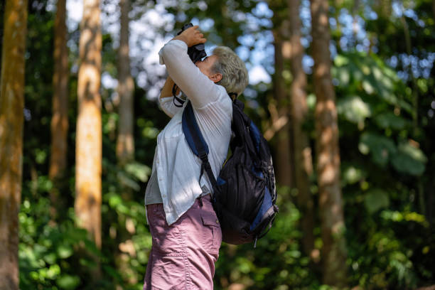 istock Backpack tourist travel outdoor adventure bird study using binoculars looking and record to book 1437948405
