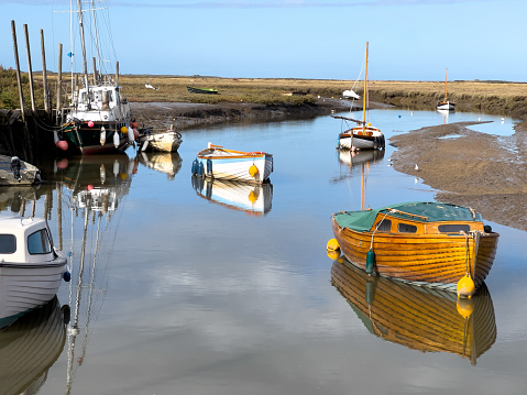 View of the tidal inlet to the harbour and quay in the north Norfolk village of Blakeney, UK.