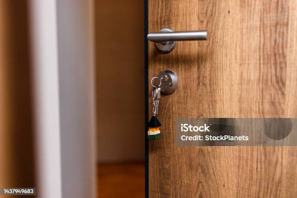 Open Door And Door Handle With A Key And A Keychain Shaped House Stock Photo - Download Image Now