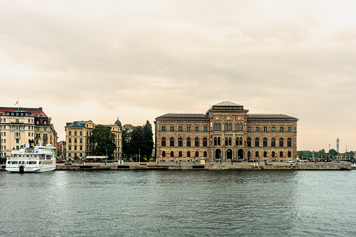 Stockholm, Sweden - September 11, 2021: Waterfront facade front view of the national museum of art, Nationalmuseum, with incidental people and twilight sky in Stockholm Sweden September 11, 2021.