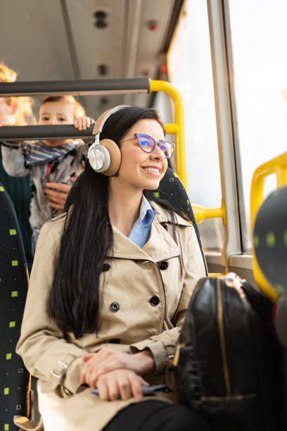 Smiling woman whit headphones traveling by bus