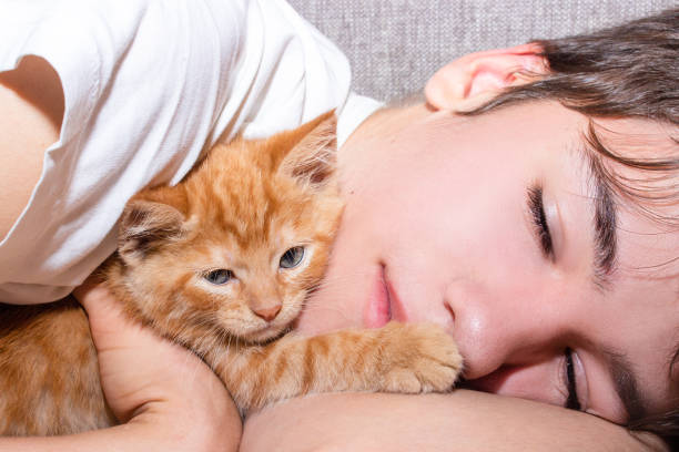 istock Teenager hugging a ginger tabby kitten 1437953329