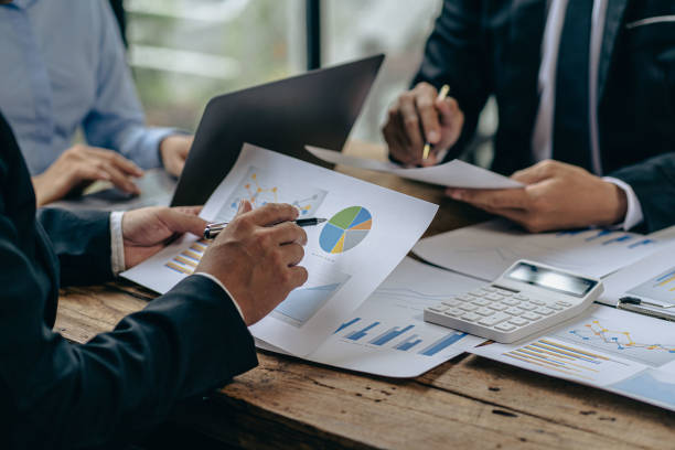 ビジネスチームは、グラフデータ、市場成長レポート、利益戦略計画、財務投資アドバイザー、企業会計のアイデアに関するプレゼンテーションとブレーンストーミングを使用して作業分析� - tax graph financial report finance ストックフォトと画像