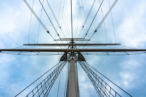 Horizontal view of sailing boat masts against sky background
