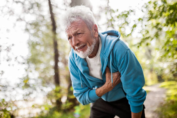 senior man athlete having heart problems during jogging - chest pain imagens e fotografias de stock