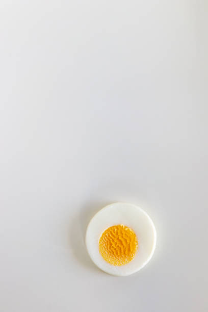 Single hard boiled egg slice on white background. Single hard boiled egg slice on white background. boiled egg cut out stock pictures, royalty-free photos & images