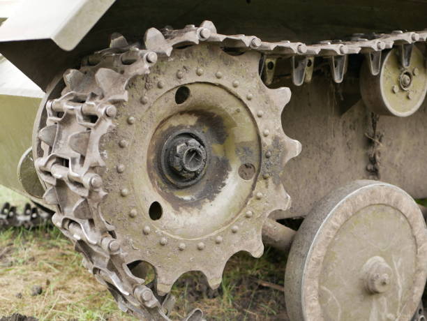 Metal tracks on a tank from the Second World War. Rubberized wheels of ancient armored vehicles. A tank painted in camouflage color on a forest road. Rubberized wheels of ancient armored vehicles. Metal tracks on a tank from the Second World War. A tank painted in camouflage color on a forest road. armored truck stock pictures, royalty-free photos & images