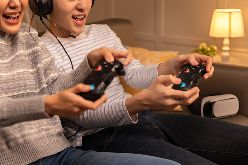 A group of young male and female friends playing video games using a video game console in an apartment.