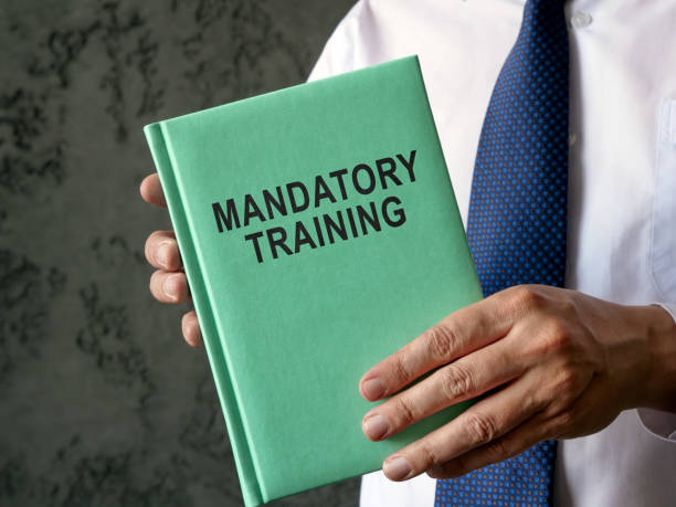 istock Employee holds mandatory training guide in the hands. 1437958721
