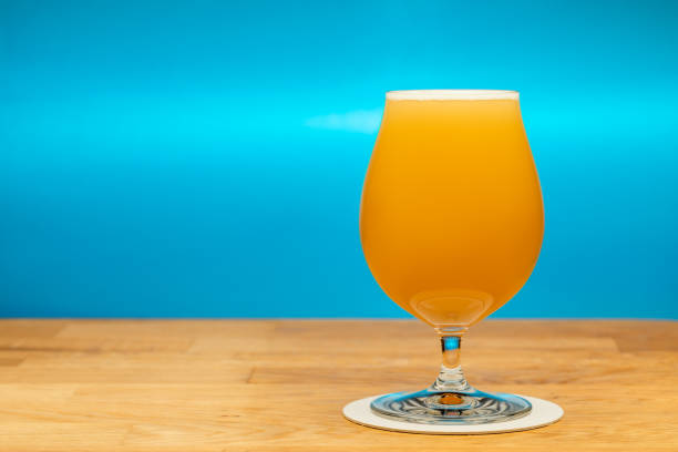 istock Full tulip glass of NEIPA ale beer on a table 1437959708