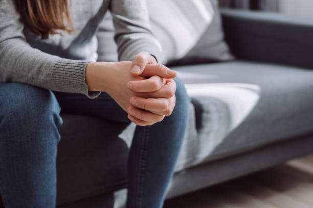 istock Unrecognizable female folded hands on knees together, sitting on couch alone, upset depressed girl feeling lonely, suffering from domestic violence or relationship problem, break up with boyfriend 1437963467