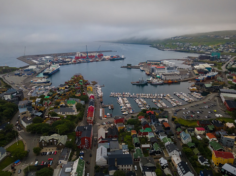 Beautiful aerial view of the City of Torshavn Capital of Faroe Islands- View of Cathedral, colorful buildings, marina, suburbs and Flag