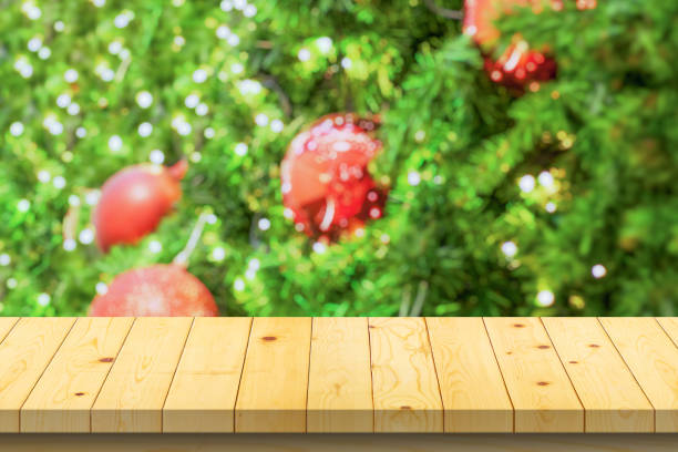 istock Empty wood table top with blur Christmas tree with bokeh light background 1437970710