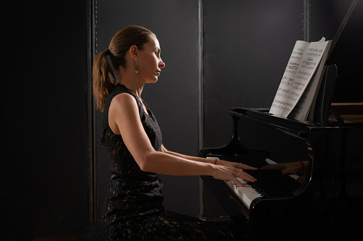 Pianist musician piano music playing. Musical instrument grand piano with woman performer