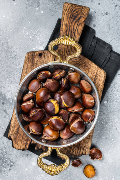 istock Cracked roasted chestnuts served in a skillet. Gray background. Top view 1437972517