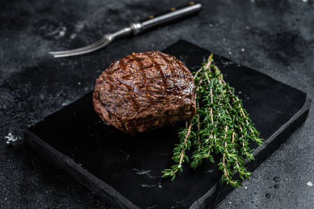 istock Grilled Rump steak with spices, cooked beef meat. Black background. Top view 1437973333
