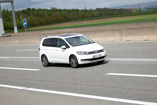 Diedenbergen, Germany - May 06, 2021: VW Touran on a highway nearby Wiesbaden, Germany. Volkswagen Touran is a compact MPV and was introduced in 2003. VW is a brand of the Volkswagen Group, which is a German automobile manufacturing group based in Wolfsburg, Germany and founded in 1937.