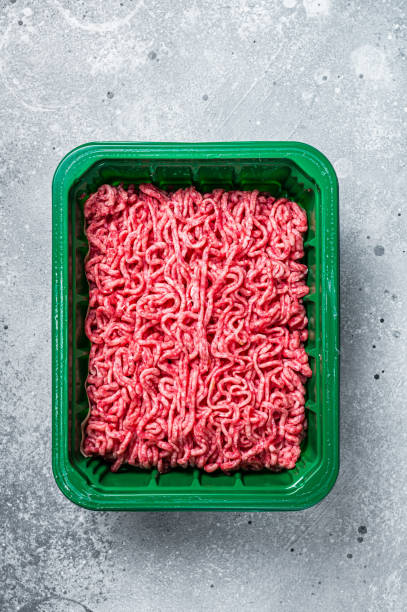 istock Raw Minced Meat in a Plastic Container, ground beef. Gray background. Top view 1437973886