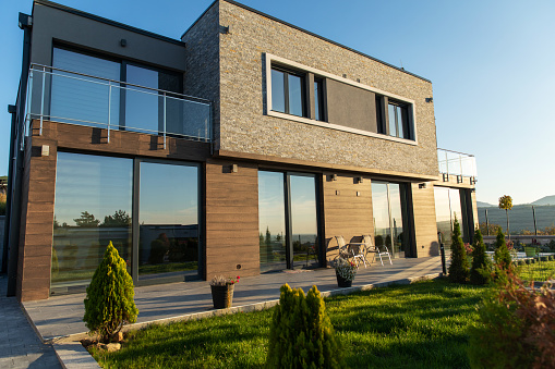 Luxury modern house with large windows and dark wood siding