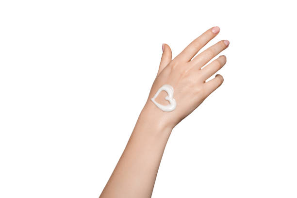 Heart shape created from cream on woman hand. stock photo