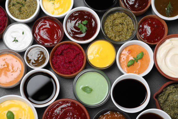 istock Many different sauces and herbs on black table, flat lay 1437980831