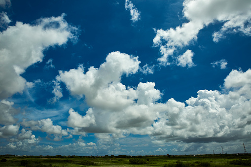 Dramatic Cloudscape in the blue sky. Multiple layers Clouds from far composed of dark and white Clouds.