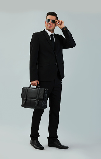 Businessman with stylish leather briefcase on light background