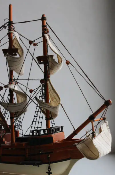 Front part and bowsprit of a wooden toy model of a sailing ship on a white background detailed stock photo