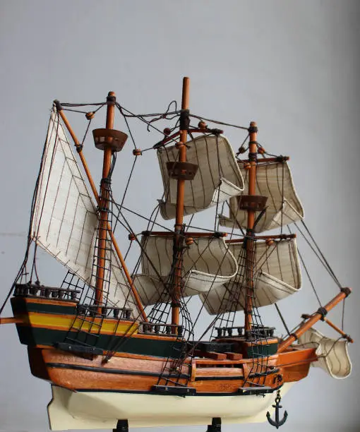 Wooden Model Of A Sailing Frigate With Sails On The Masts On White Background For Vertical Story