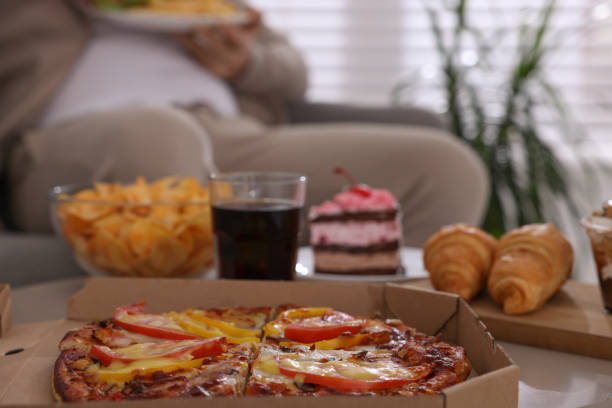 istock Overweight man at home, focus on pizza 1437983750