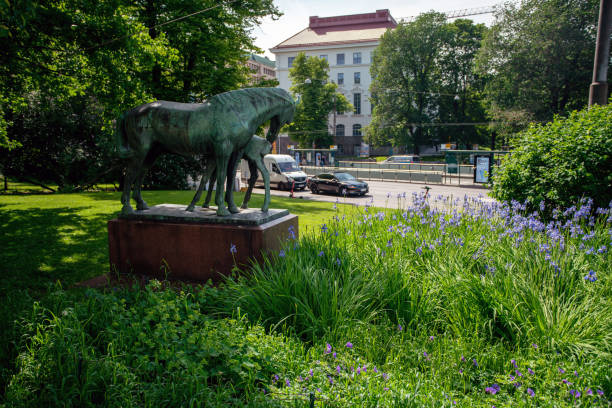 istock Awe horses statues and garden  in downtown. Traffic 1437984214