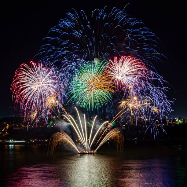 istock Beautiful shot of firework explosions over a river in the dark 1437984556