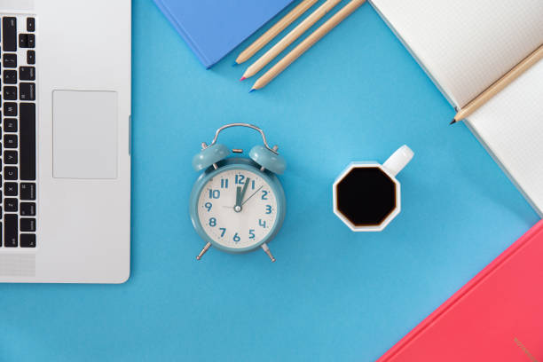 istock Flat lay, alarm clock and a cup of coffee in the workplace. 1437984868