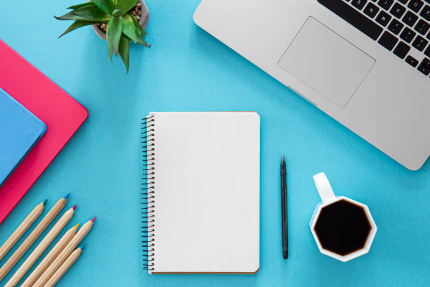 istock Flat lay, notepad, laptop and stationery on blue background. 1437984870