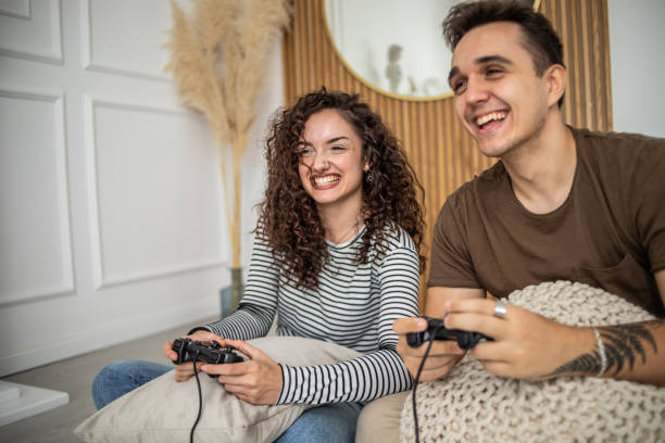 istock Young couple playing video games on console at home, having a good time 1437986791
