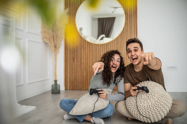 istock Young couple playing video games on console at home, having a good time 1437986812